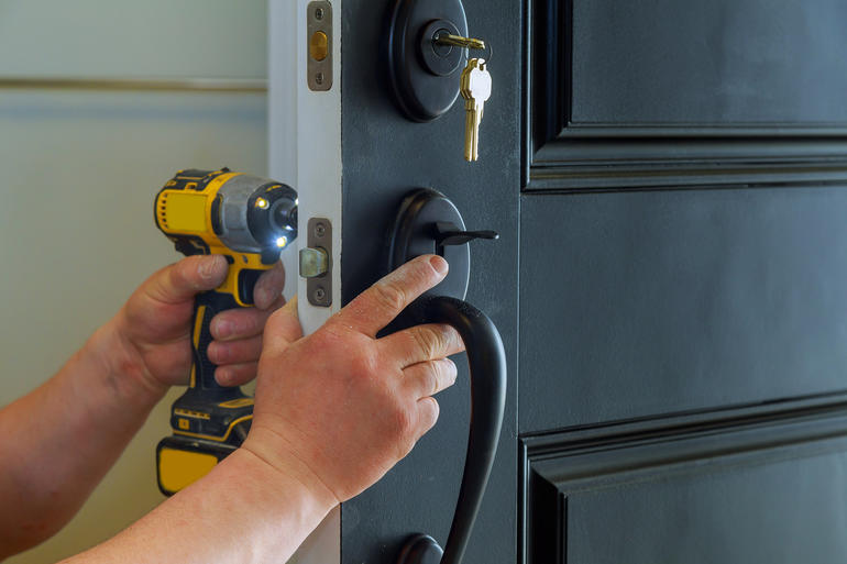 Saskatoon residential locksmith changing a front door deadbolt at family home